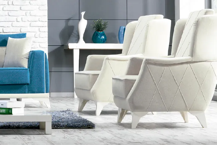 Sillones tapizados blancos junto a un sofá azul